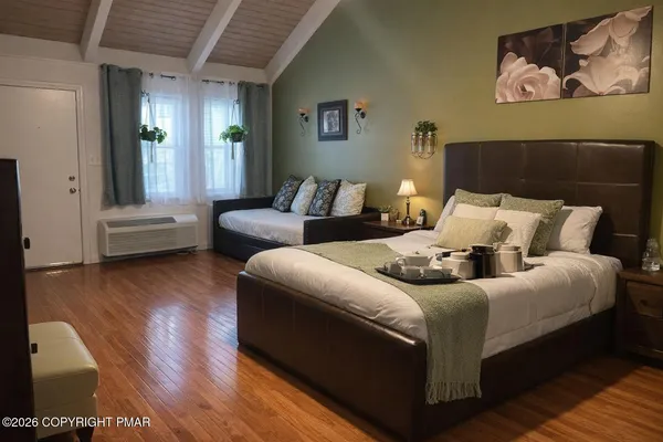 a bedroom with a bed and wooden floor