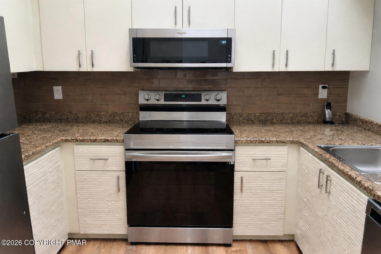 113 Condor Drive, Unit 30 Tamiment, PA 18371 - Photo 10 of 20 a kitchen with stainless steel appliances granite countertop a stove microwave and sink