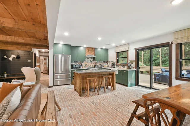 a living room with furniture a flat screen tv and kitchen view