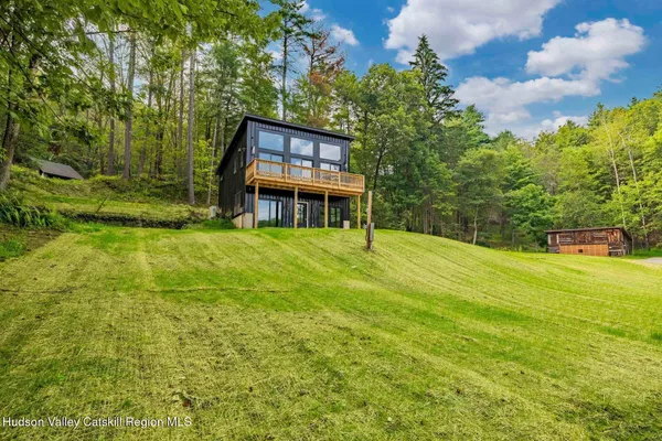 an aerial view of residential house with outdoor space and trees all around