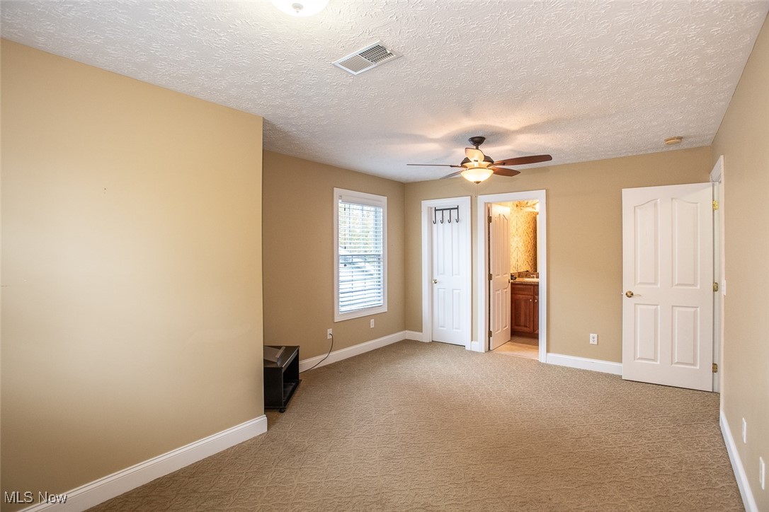 630 Rundle Street Lagrange, OH 44050 - Photo 34 of 49 Unfurnished bedroom with light carpet, ensuite bath, a textured ceiling, and a ceiling fan