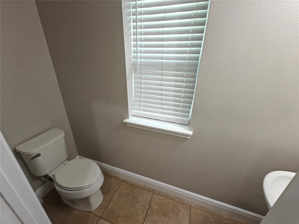 8075 Schelling Street Orlando, FL 32827 - Photo 16 of 51 a white toilet sitting next to a window
