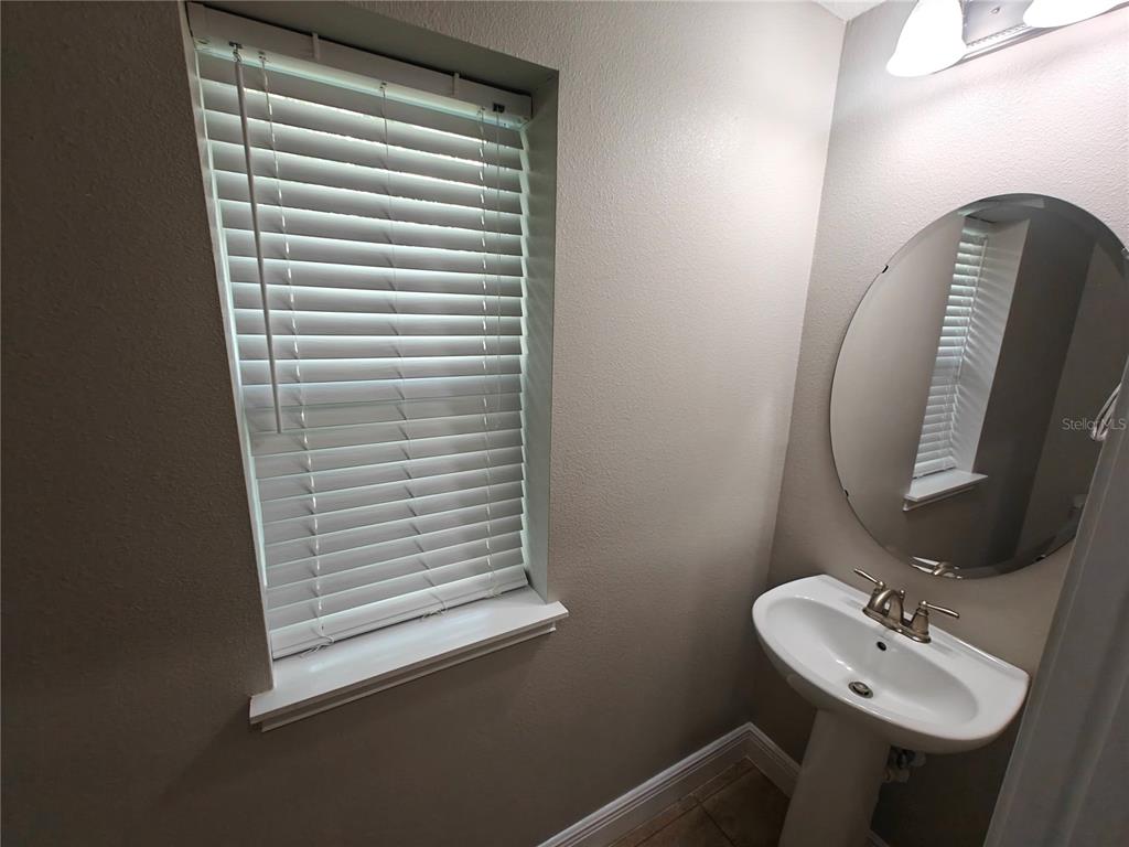 8075 Schelling Street Orlando, FL 32827 - Photo 17 of 51 a bathroom with a sink and a mirror