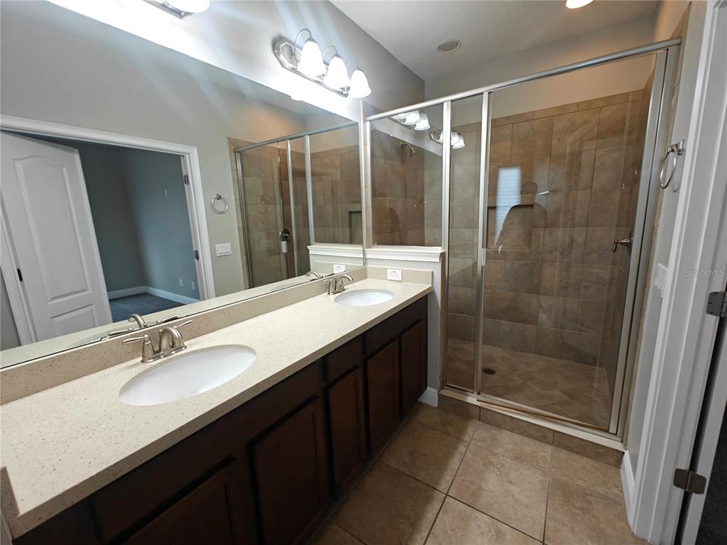 8075 Schelling Street Orlando, FL 32827 - Photo 28 of 51 a bathroom with a double vanity sink mirror and shower