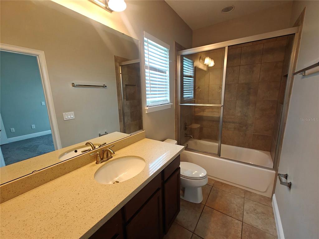8075 Schelling Street Orlando, FL 32827 - Photo 40 of 51 a bathroom with a granite countertop sink toilet and shower