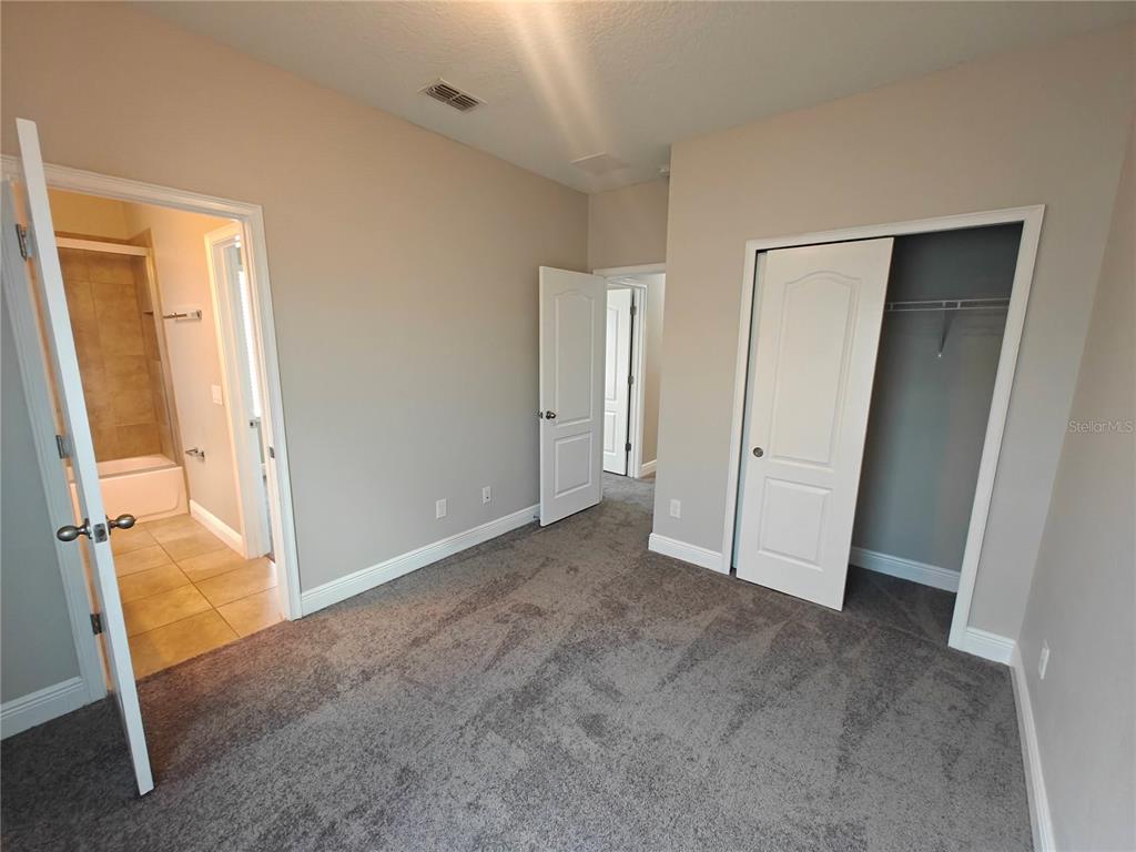 8075 Schelling Street Orlando, FL 32827 - Photo 41 of 51 an empty room with sliding door and wooden floor