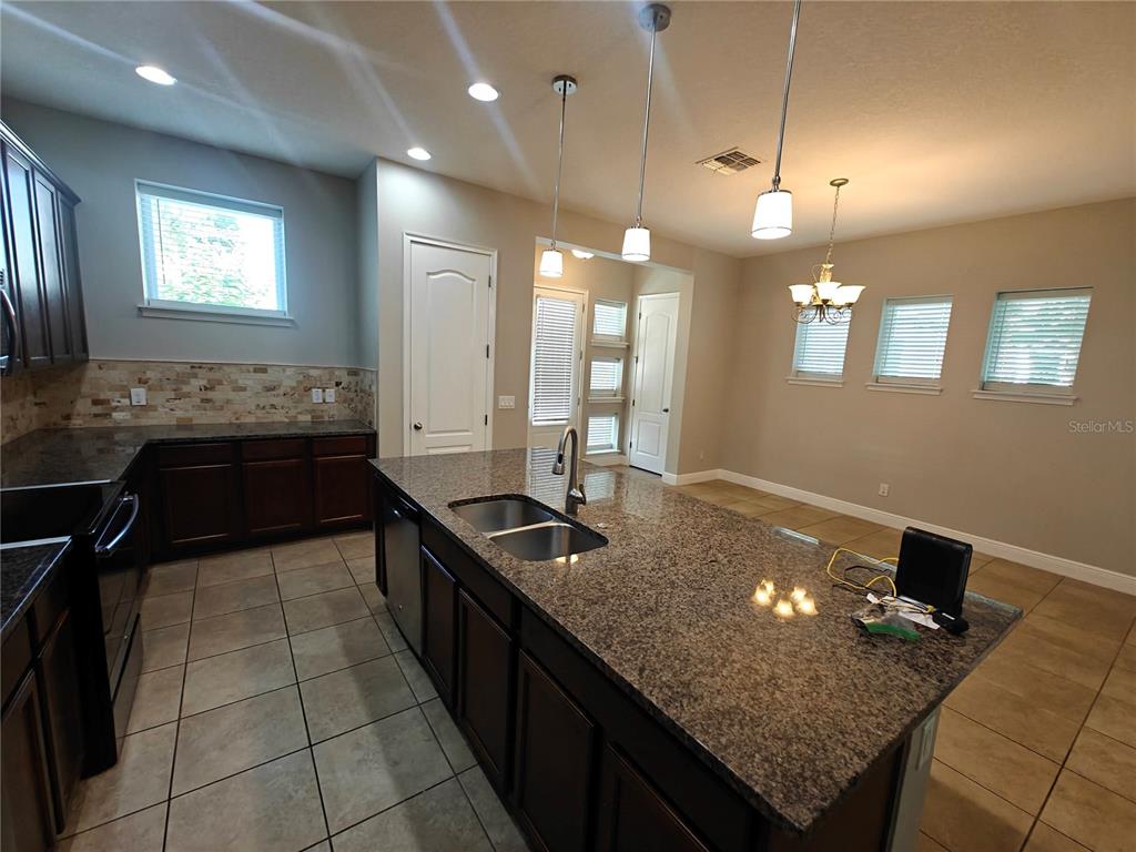 8075 Schelling Street Orlando, FL 32827 - Photo 5 of 51 a kitchen with granite countertop a sink and a stove