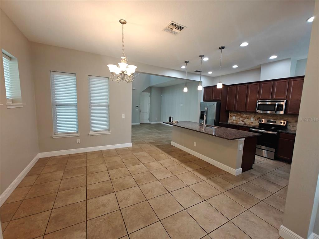 8075 Schelling Street Orlando, FL 32827 - Photo 6 of 51 a large kitchen with granite countertop a sink and cabinets