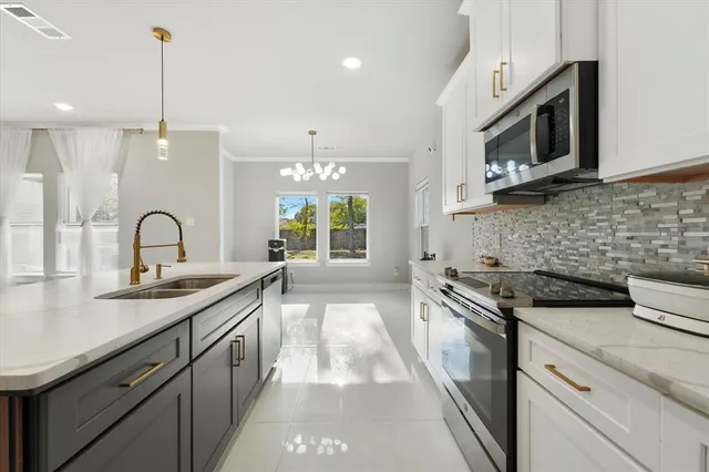 a kitchen with granite countertop a sink stainless steel appliances and cabinets