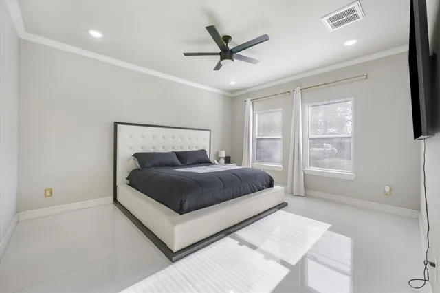 a bedroom with a large bed and a ceiling fan