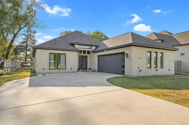 a view of a white house with a yard and large tree