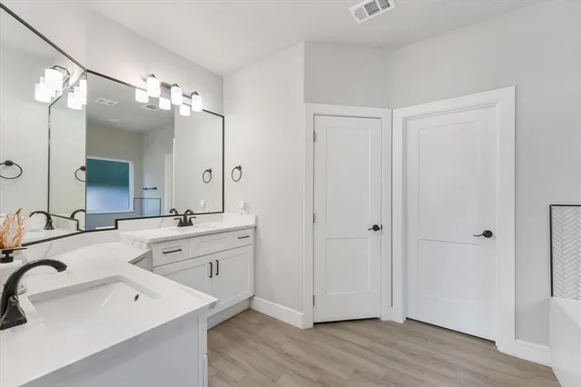 a spacious bathroom with a double vanity sink mirror and shower