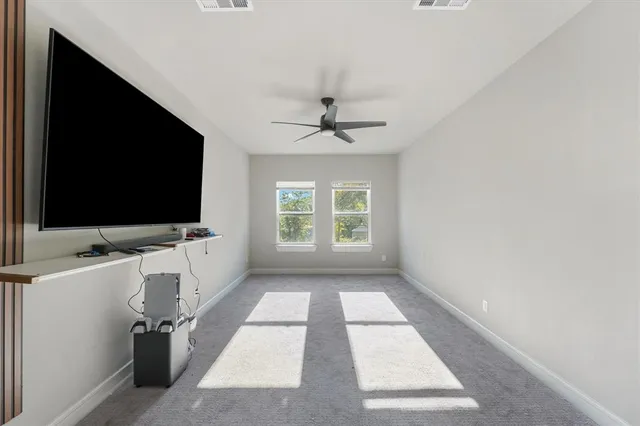 an empty room with windows flat screen tv and windows