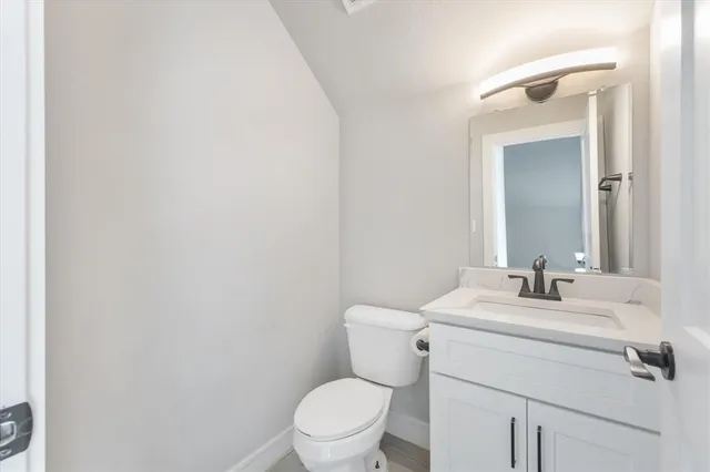 a bathroom with a toilet sink vanity and mirror