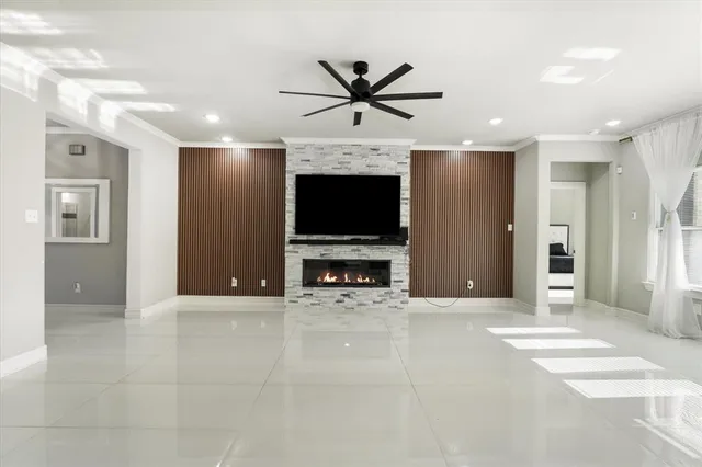a view of a livingroom with a flat screen tv wooden floor and a ceiling fan