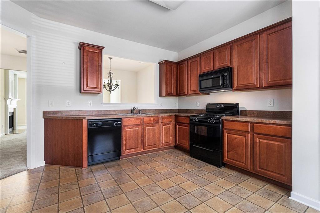 3656 Chicago Street Northwest Suwanee, GA 30024 - Photo 12 of 26 a kitchen with stainless steel appliances granite countertop a stove top oven a sink dishwasher and a microwave oven on the blue kitchen countertops