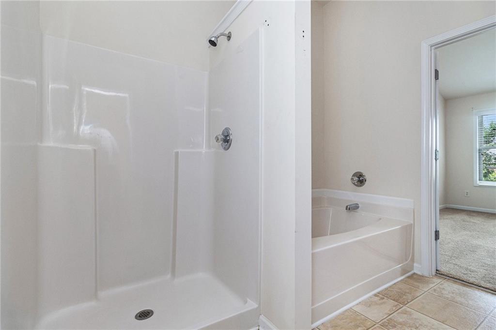 3656 Chicago Street Northwest Suwanee, GA 30024 - Photo 16 of 26 a bathroom with a bathtub and a shower