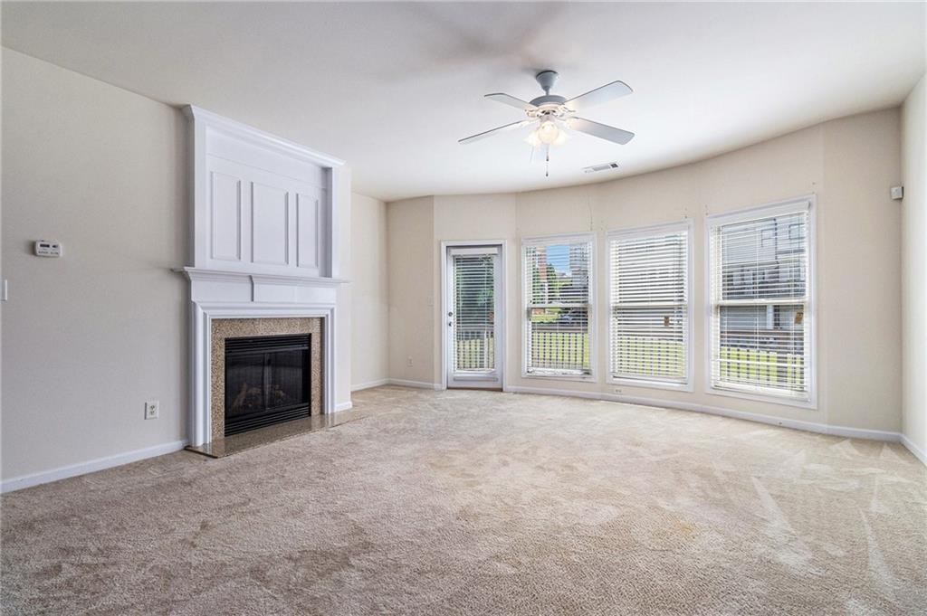 3656 Chicago Street Northwest Suwanee, GA 30024 - Photo 6 of 26 a view of an empty room with chandelier fan and fire place