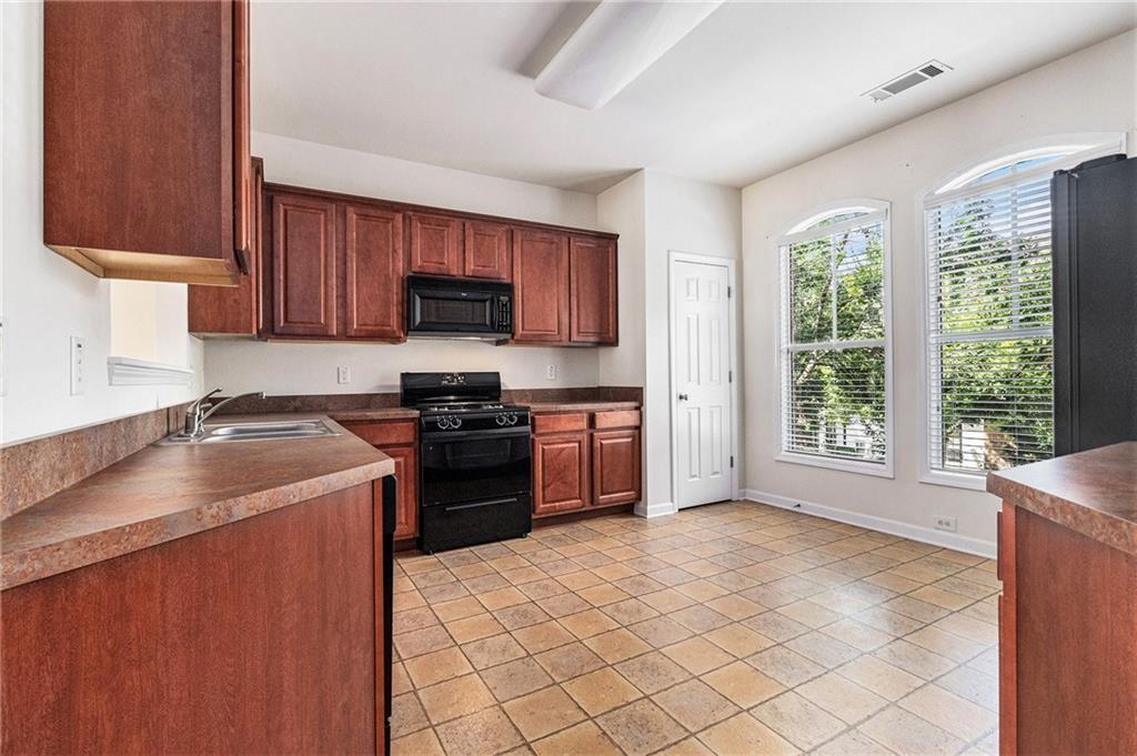 3656 Chicago Street Northwest Suwanee, GA 30024 - Photo 10 of 26 a kitchen with a stove top oven sink and cabinets