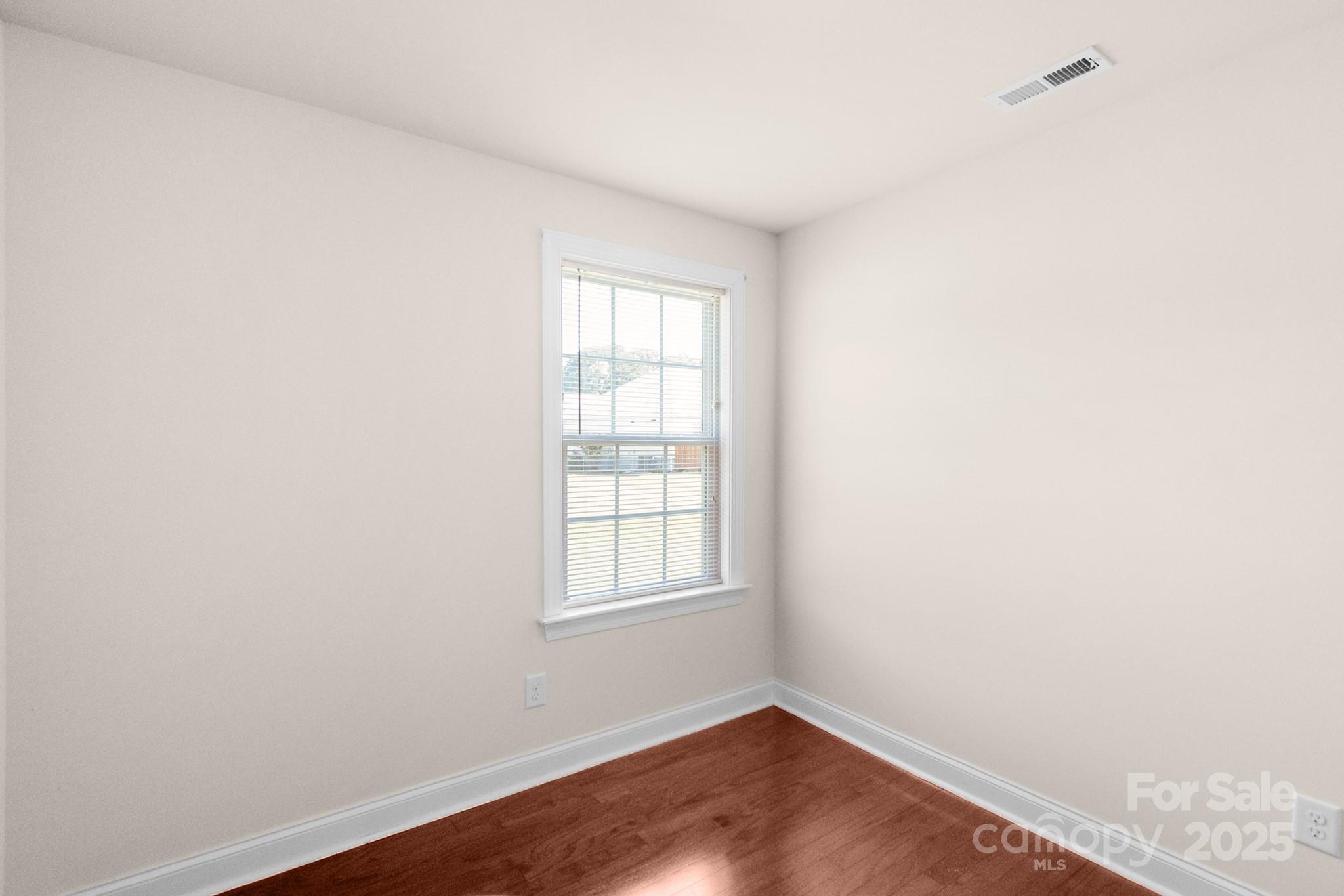 169 Abigail Lane Locust, NC 28097 - Photo 12 of 18 an empty room with wooden floor and windows