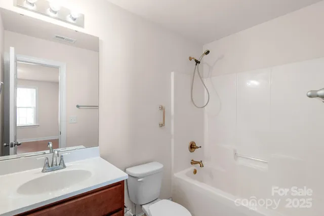 a bathroom with a sink vanity mirror and toilet