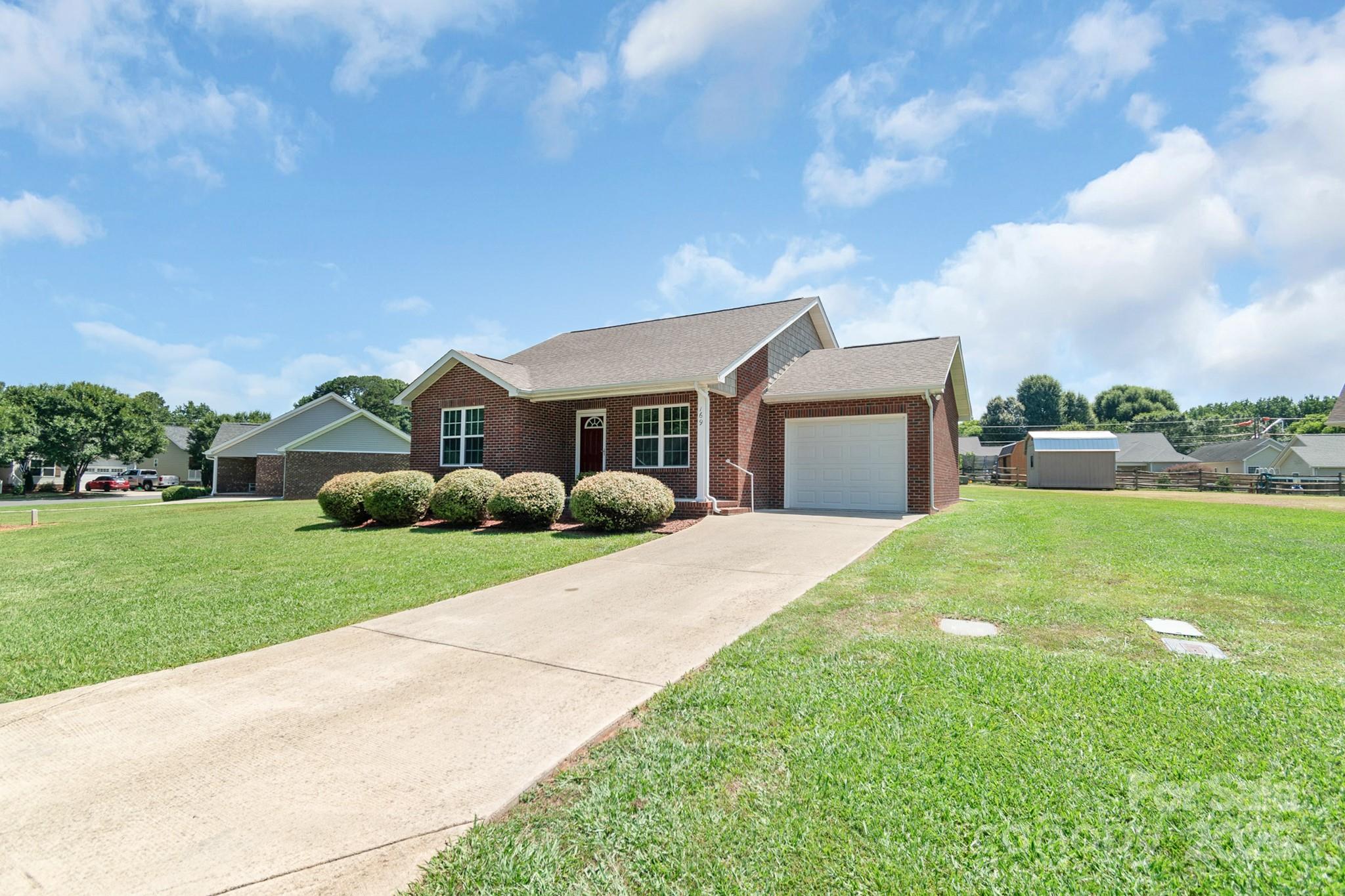 169 Abigail Lane Locust, NC 28097 - Photo 4 of 18 a front view of a house with a yard and garage