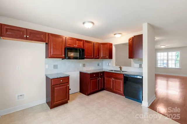 a large kitchen with stainless steel appliances granite countertop a stove sink and cabinets