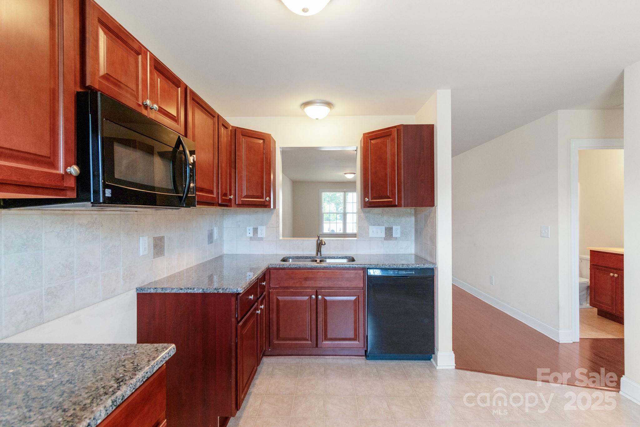 169 Abigail Lane Locust, NC 28097 - Photo 9 of 18 a kitchen with stainless steel appliances granite countertop a sink stove and microwave