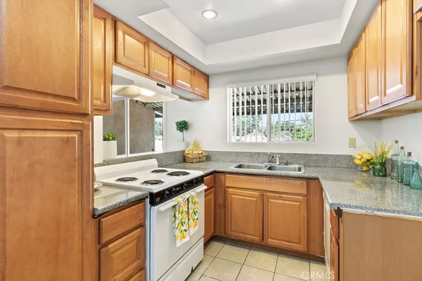 a kitchen with stainless steel appliances granite countertop a sink a stove and a refrigerator