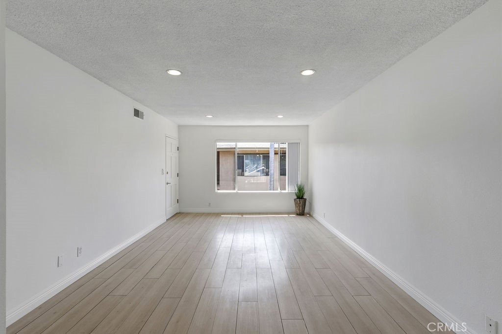 1801 Greenleaf Street, Unit 15 Santa Ana, CA 92706 - Photo 22 of 26 a view of an empty room with wooden floor and a window