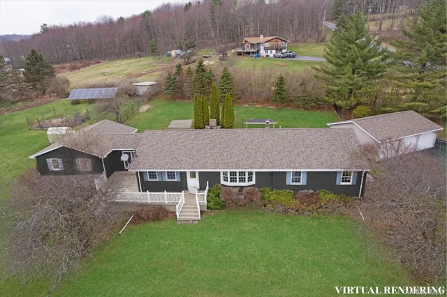 an aerial view of a house with garden space and a pond