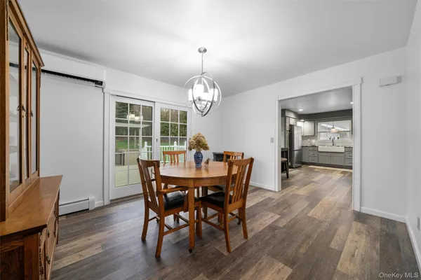 a dining room with wooden floor a chandelier a wooden table and chairs