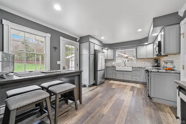 a kitchen with a table chairs refrigerator and window