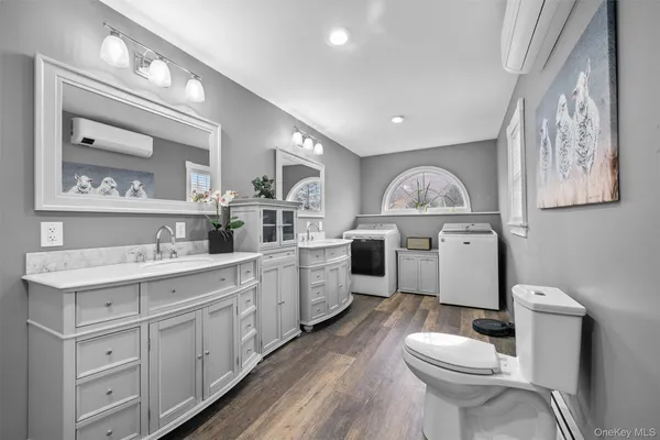 a bathroom with a sink vanity mirror and toilet