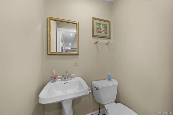 a bathroom with a toilet a sink and mirror