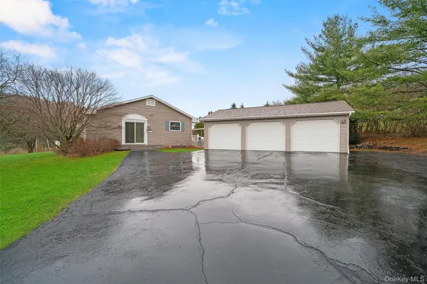 a view of a house with a yard and large tree