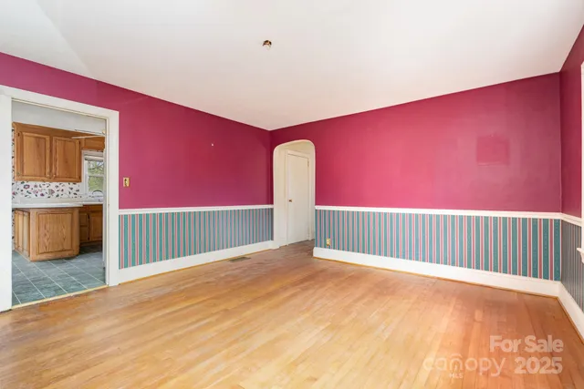 a view of an empty room with a fireplace and a window