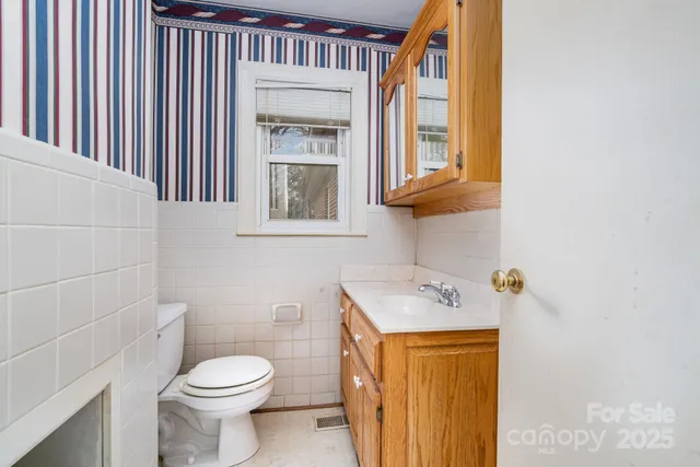 a front view of a house with a yard and large trees