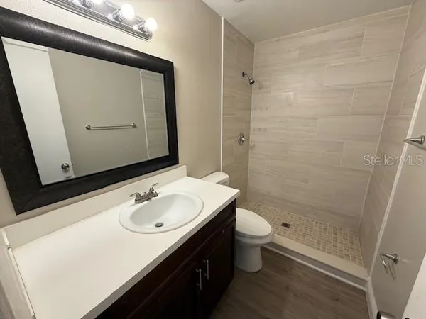 a bathroom with a sink a toilet and shower