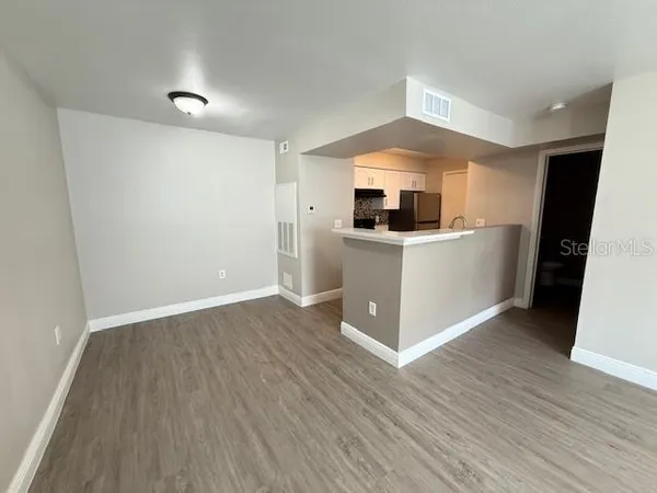 a view of kitchen with wooden floor and electronic appliances