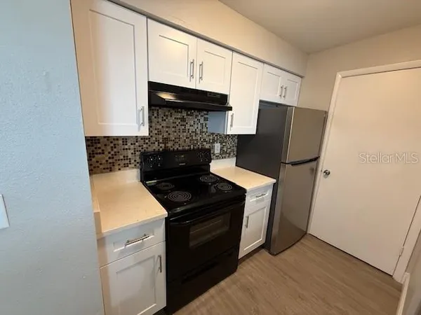 a kitchen with stainless steel appliances granite countertop a stove a refrigerator and a microwave