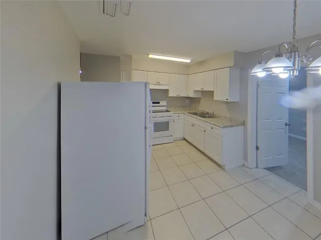 a kitchen with a cabinets and chandelier