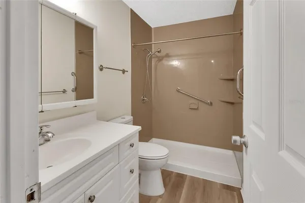 a bathroom with a sink a toilet and shower