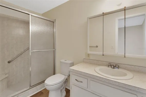 a bathroom with a granite countertop sink toilet and a mirror