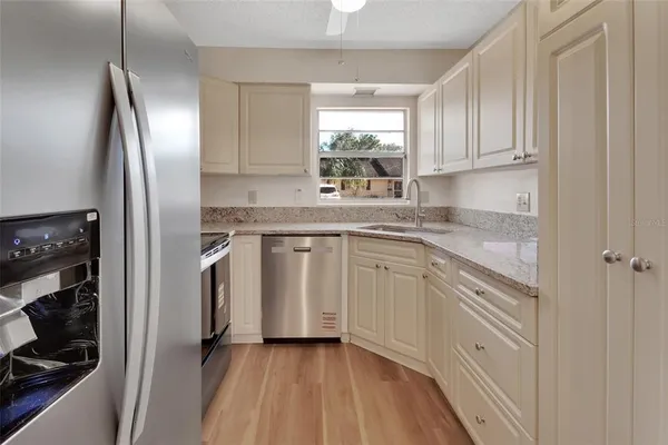 a kitchen with cabinets stainless steel appliances and sink