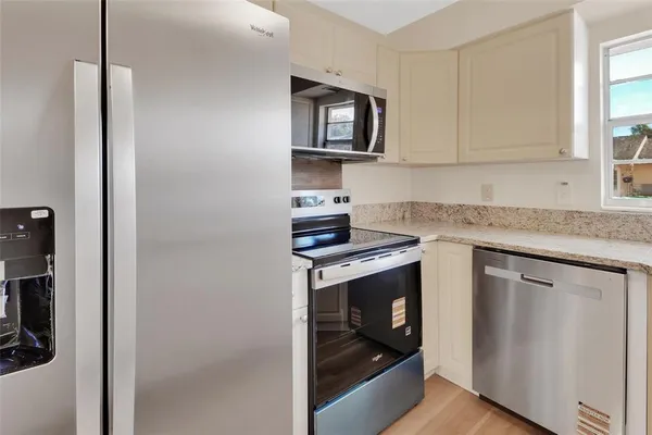 a kitchen with stainless steel appliances granite countertop a stove a microwave and a refrigerator