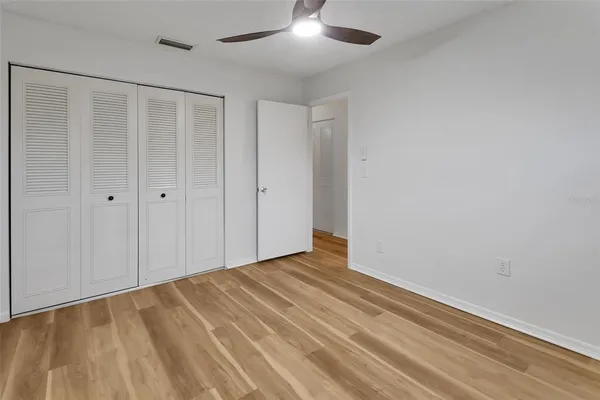 a view of an empty room with wooden floor