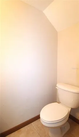 a white toilet sitting next to a white wall