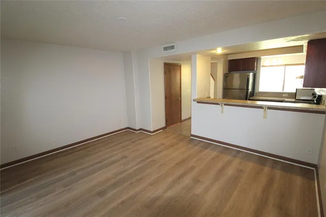 a view of a kitchen with wooden floor and electronic appliances