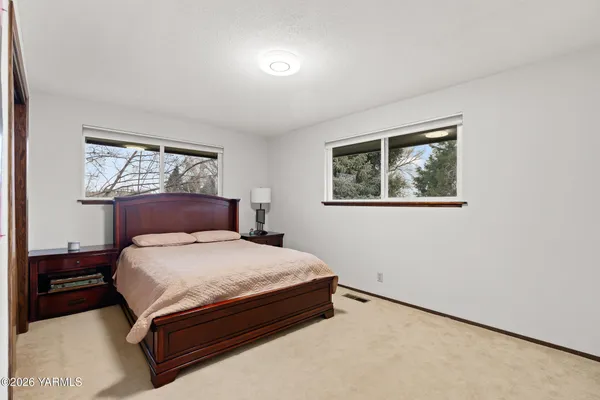 a large bed sitting in a bedroom next to a window